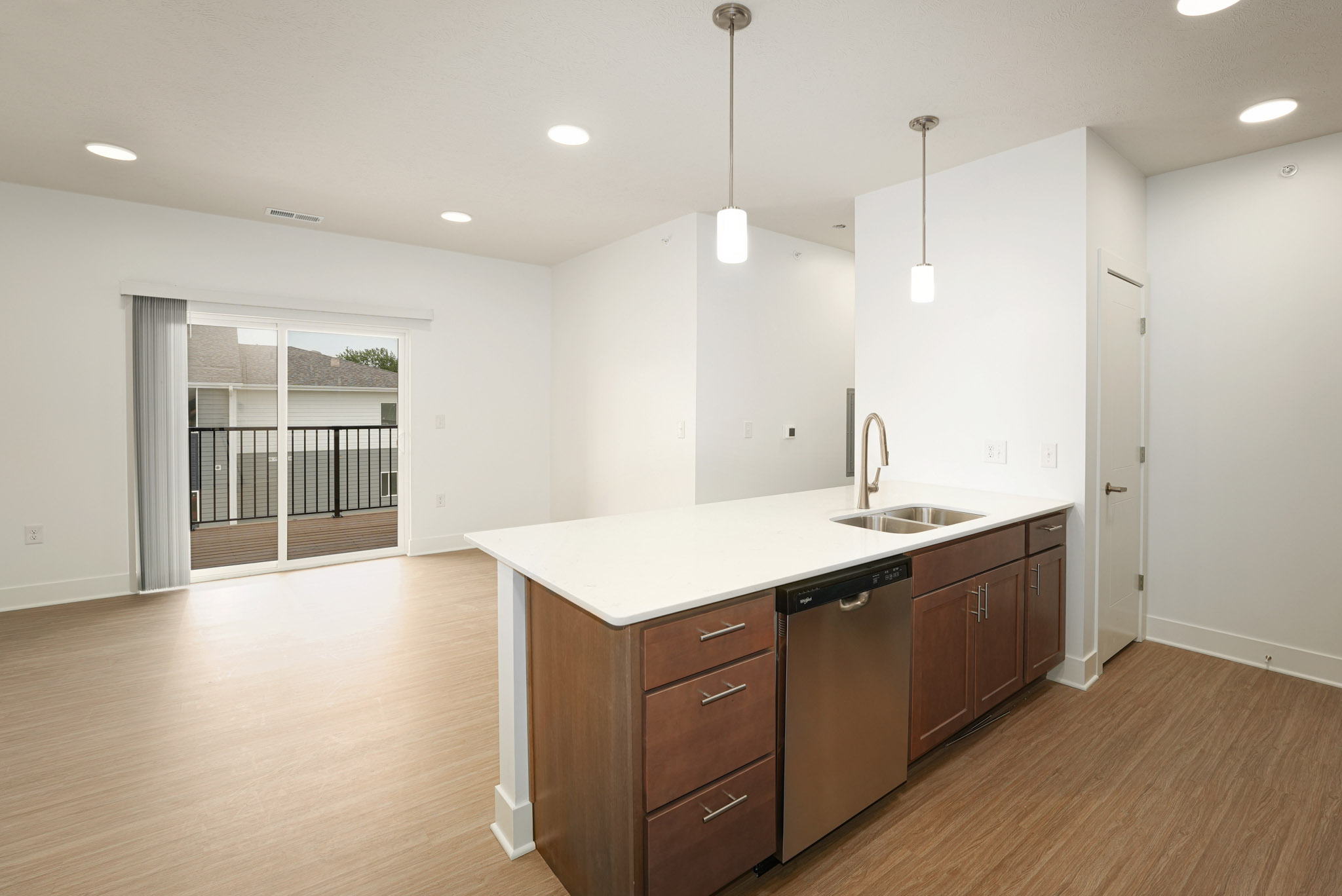 Open-concept kitchen with large island overlooking living area and private balcony access.
