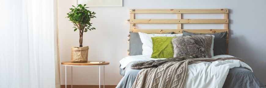 Cozy bed with wood headboard and bedside table