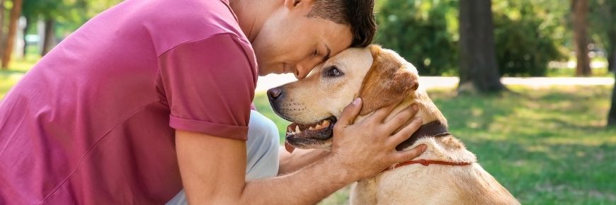 A man hugging his pet dog