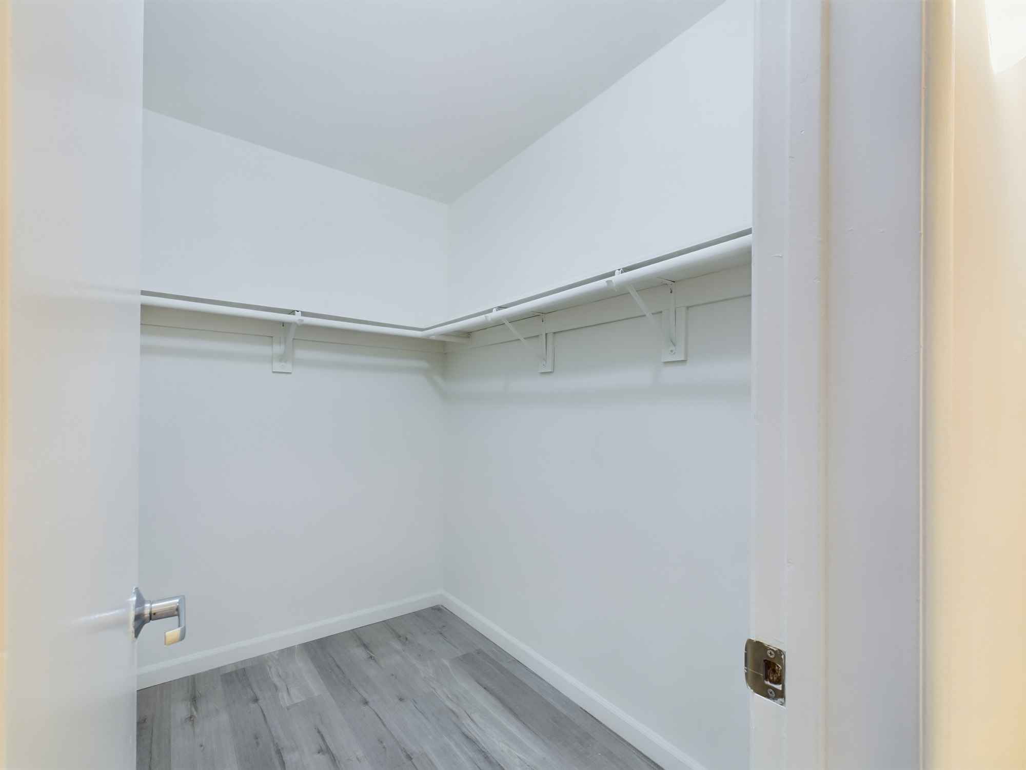 A spacious, empty closet with a hanging rod