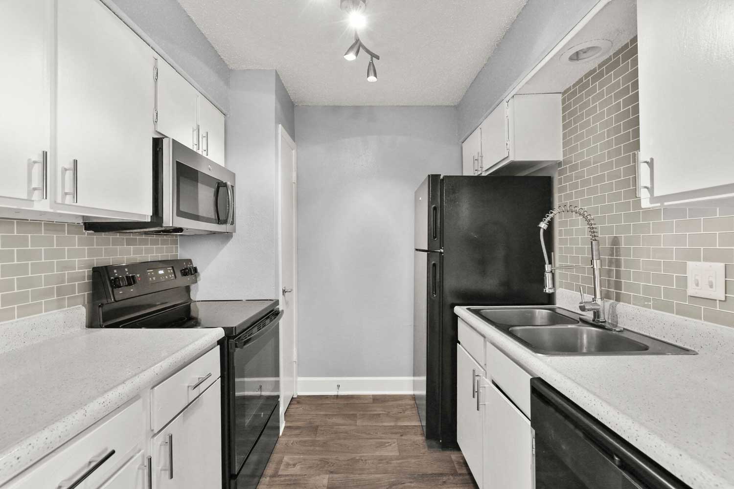 White Kitchen with Black Appliances at The Junction Apartments