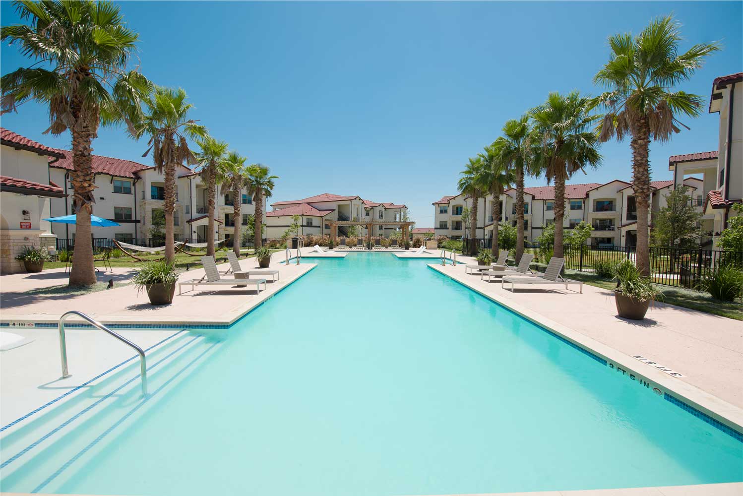 Pool Area with Sundeck and Palm Trees