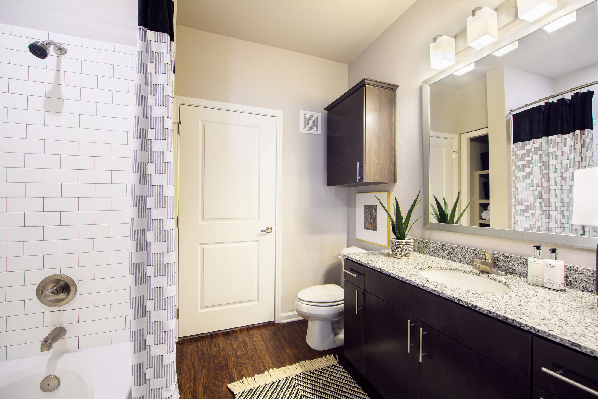 Park Rowe Village - Apartment 2331 - Bathroom with white tile and grey countertops dark cabinetry