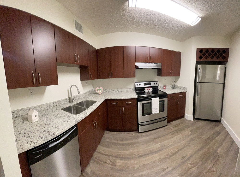 Cozy kitchen with dark wood cabinets and stainless steel appliances.