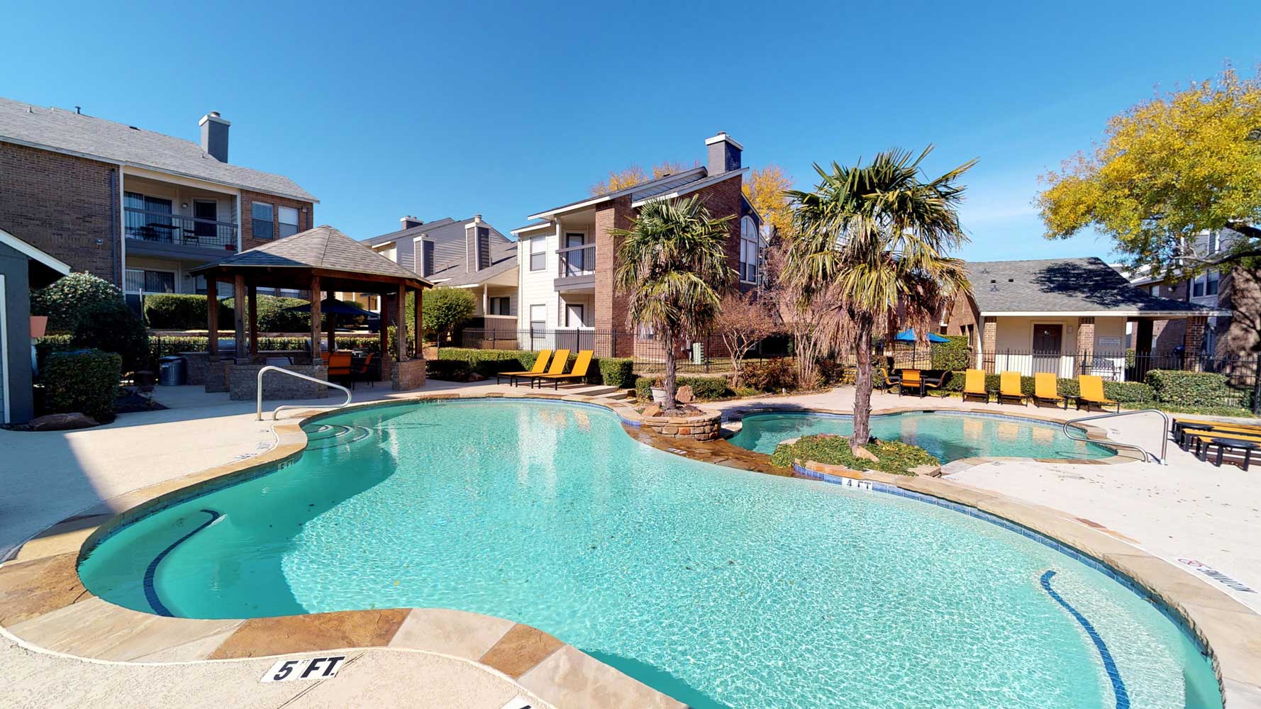 Large Pool with Palm Tree Landscaping at Ridgeview Place Apartments in Irving, TX