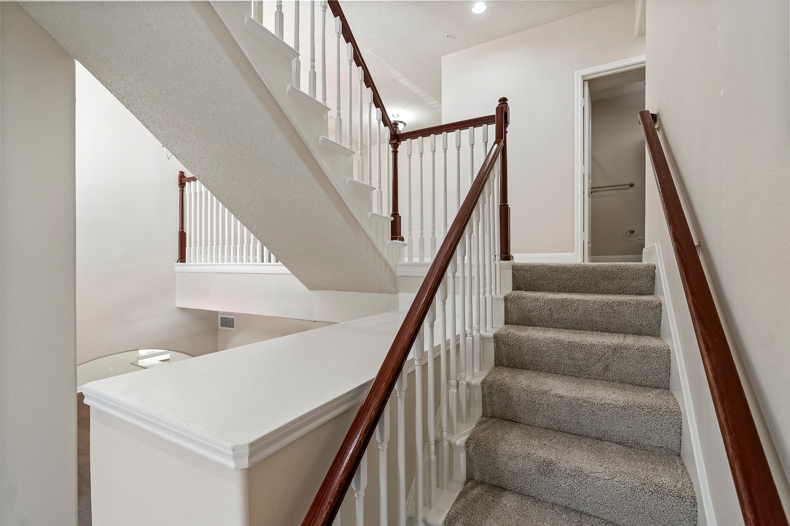 Carpeted Staircase with Wood Railing