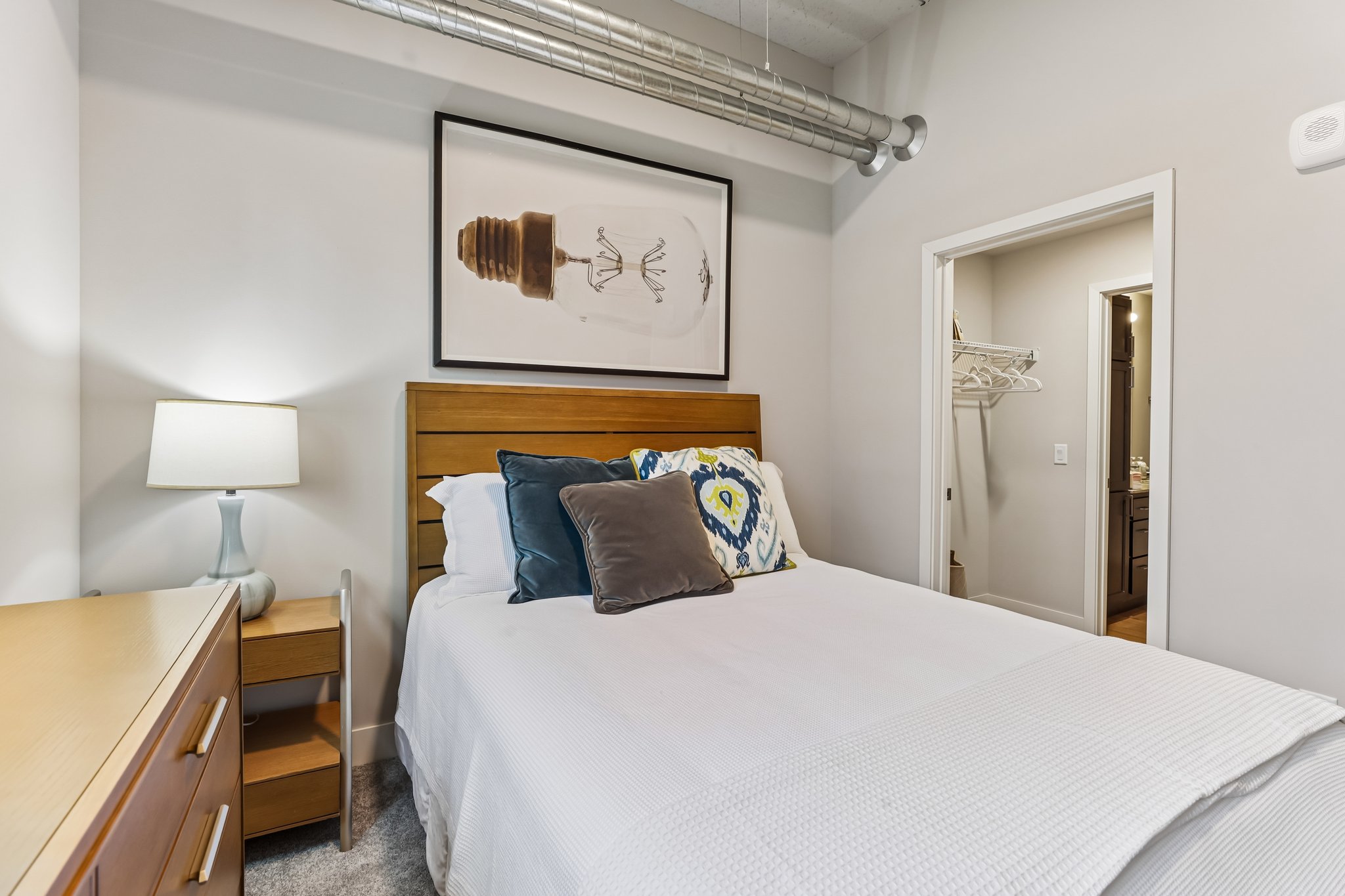 Primary bedroom in a two-bedroom income-restricted 55+ apartment at The Victoria at Huxley Yards in Madison, WI, with ceiling fan and ample natural light.