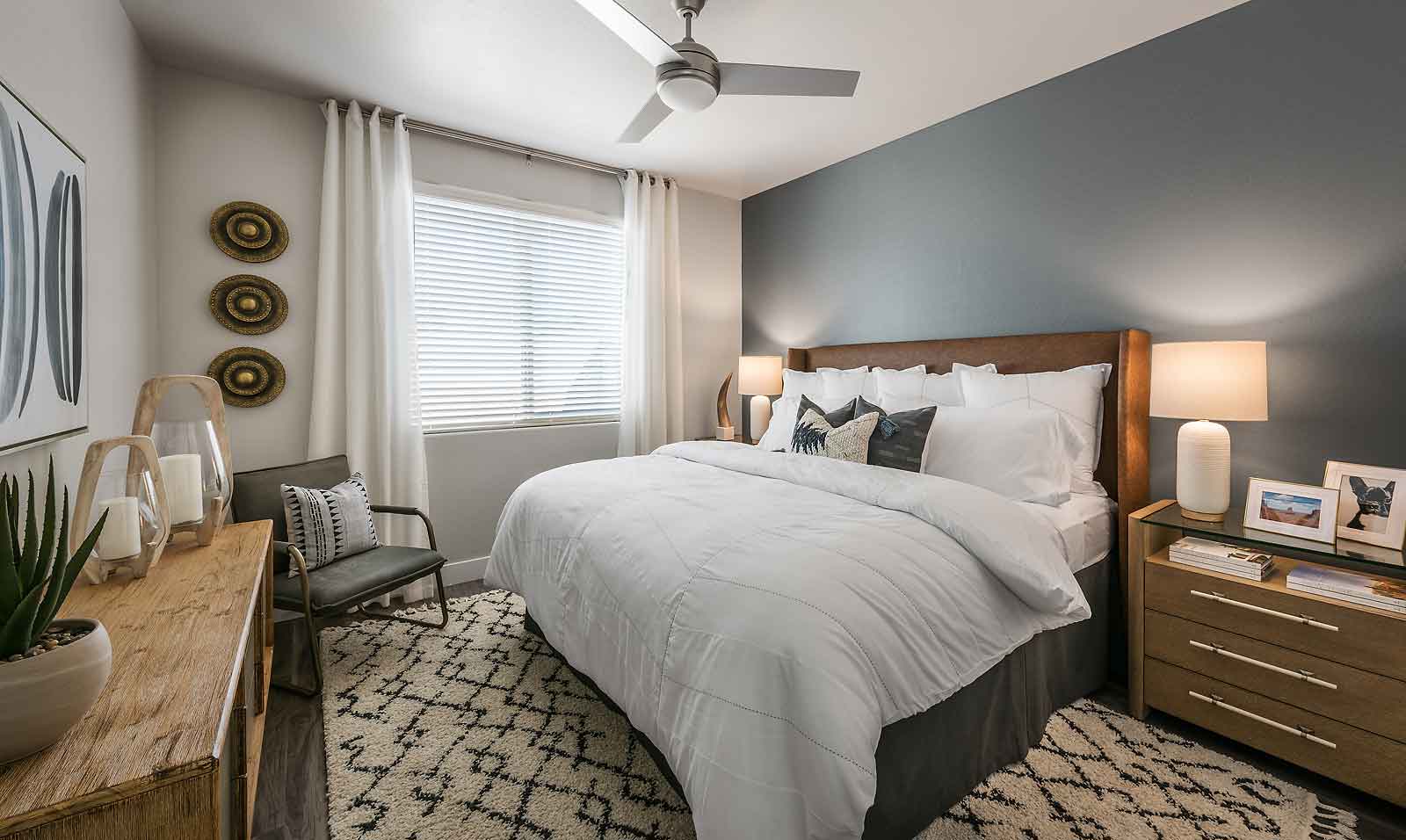 Carpeted Bedroom With Ceiling Fan at Village at Pioneer Park Apartments in Peoria, AZ