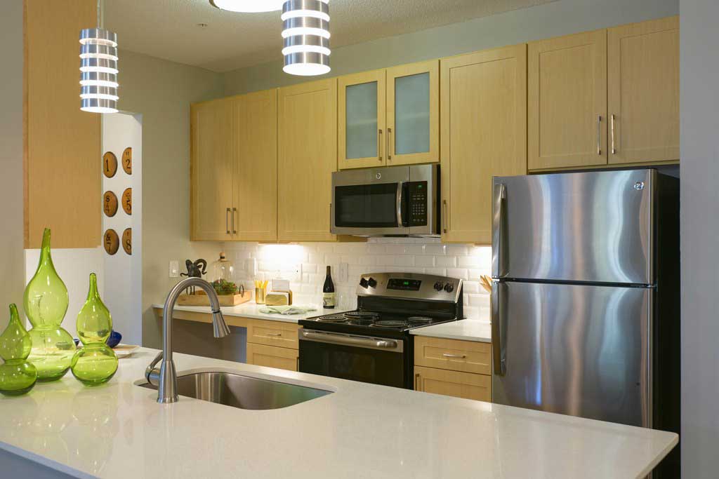 Kitchen W/ Wooden Cabinetry at Woodhaven at Park Bridge Apartments